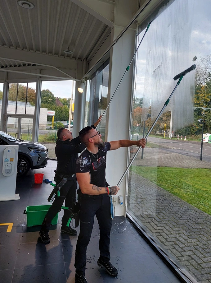 Hommes nettoyant la vitrine d'un showroom